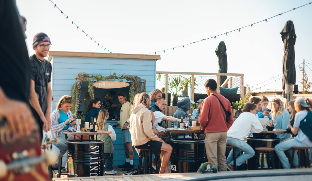 Hartbeach terras met veel gasten aan ruime tafels die genieten van de surfcultuur Foto: Zajicek Hartbeach terras met veel gasten aan ruime tafels die genieten van de surfcultuur Foto: Zajicek