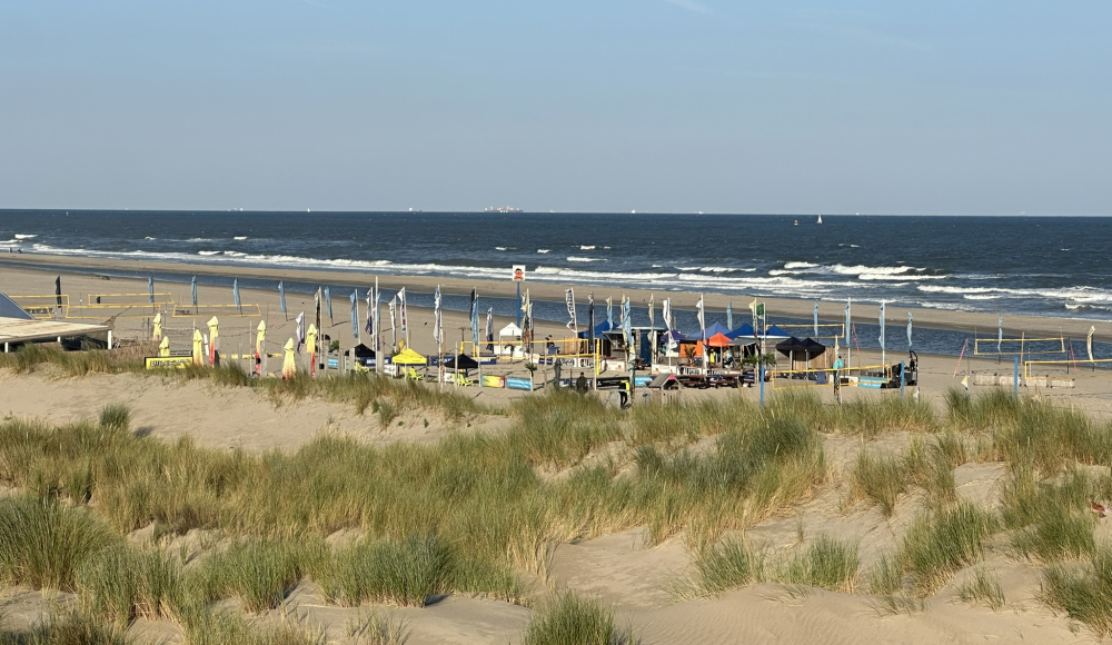 Zicht vanaf de duinen Kijkduin op het strand met de volleybalnetten.