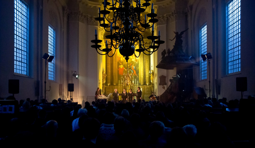 Avondconcert in de imposante Oud-Katholieke schuilkerk in Den Haag met hoge ramen, een groot kroonluchter en goud verlicht altaar Avondconcert in de imposante Oud-Katholieke schuilkerk in Den Haag met hoge ramen, een groot kroonluchter en goud verlicht altaar