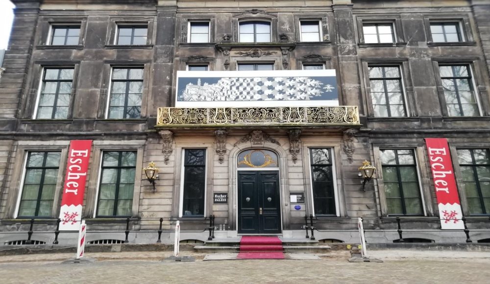 Vooraanzicht van Museum Escher in Het Paleis in Den Haag met boven de ingang een werk van M.C. Escher