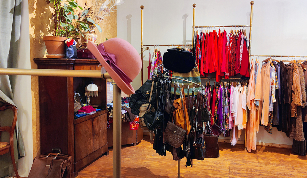 Het sfeervolle en kleurige interieur van Zusjes Vintage Boetiek met rekken vol vintage kleding.