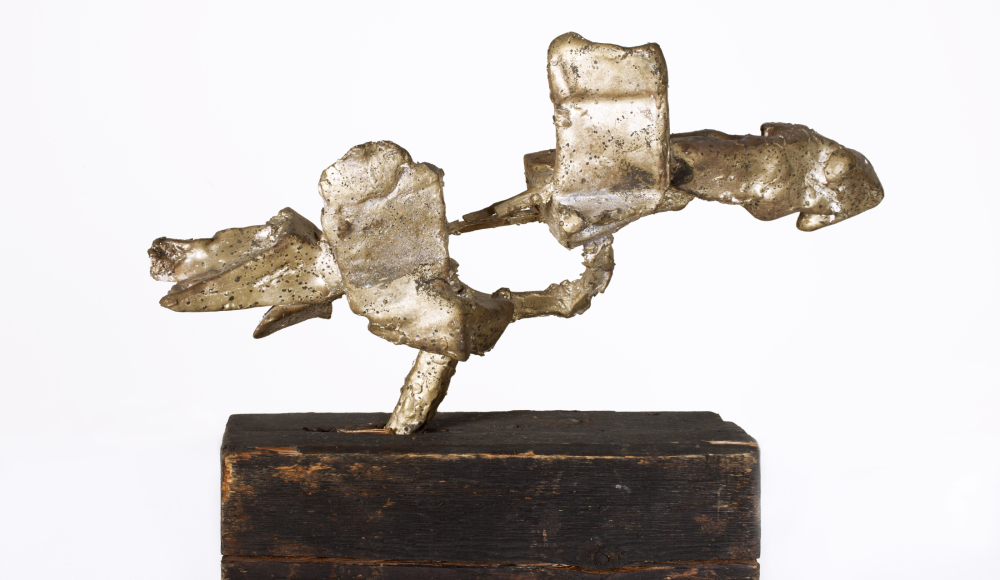 An abstract sculpture made of metal elements on a wooden base. An abstract sculpture made of metal elements on a wooden base.