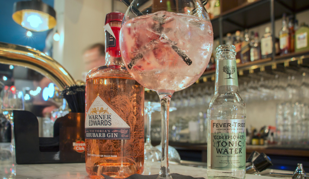 Roze rabarber gin tonic op een bar. 