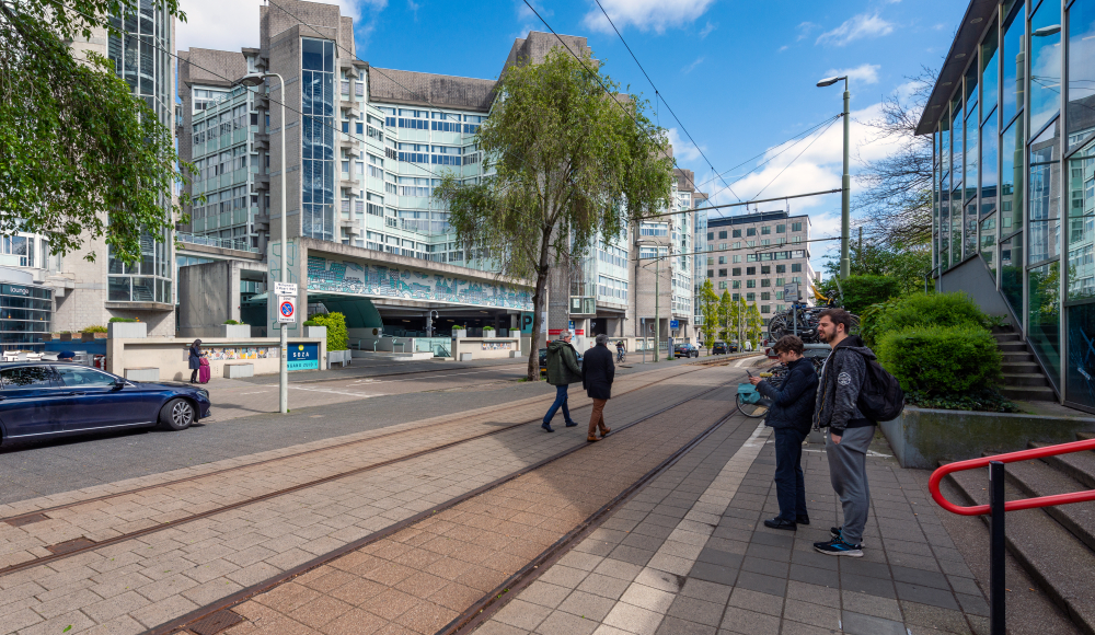 Twee mensen wachten bij een tramhalte in Den Haag.
