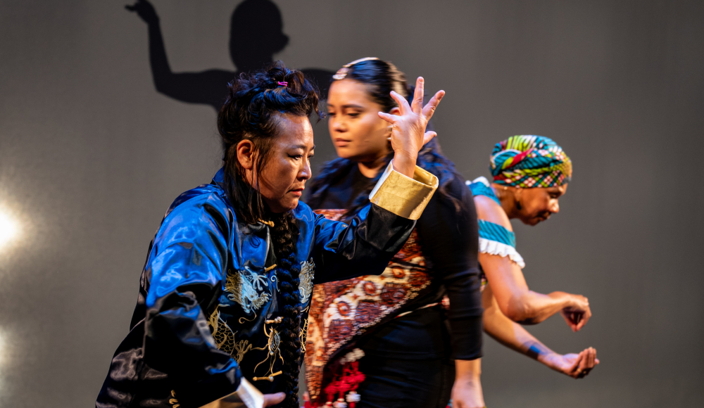 Drei Frauen in Tracht tanzen gemeinsam auf der Bühne des Théâtre de Regentes.