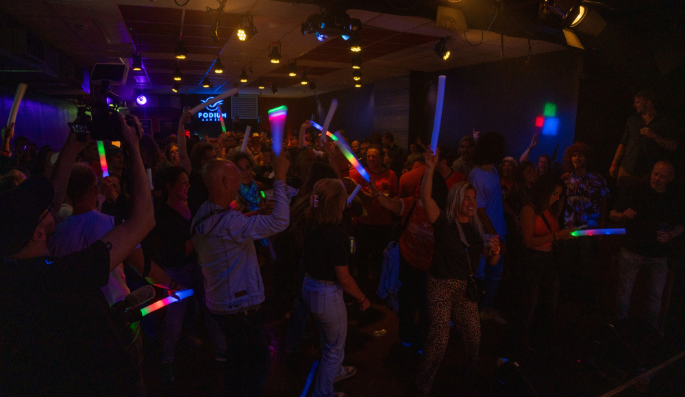 Mensen dansen in Podium aan Zee met lichtsticks. Foto: Iwan de Brabander
