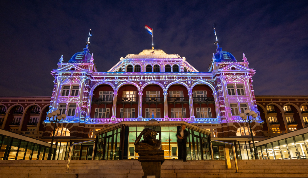 Das Kurhaus in Scheveningen, beleuchtet mit Farben und Texten.