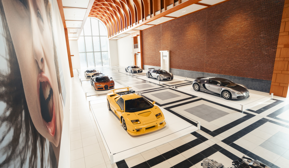 Zes luxe sportauto's in een moderne expositieruimte