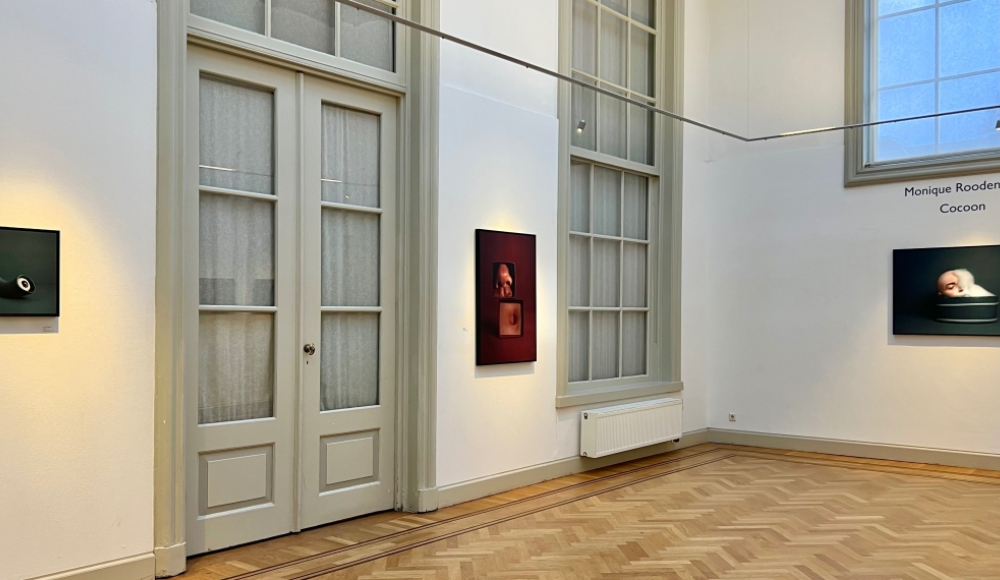 Twee kunstwerken hangen aan de muur in een lichte galerie. Twee kunstwerken hangen aan de muur in een lichte galerie.