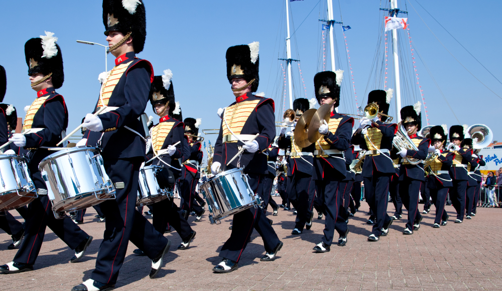 Een fanfare in uniform marcheert door de haven van Scheveningen tijdens Vlaggetjesdag