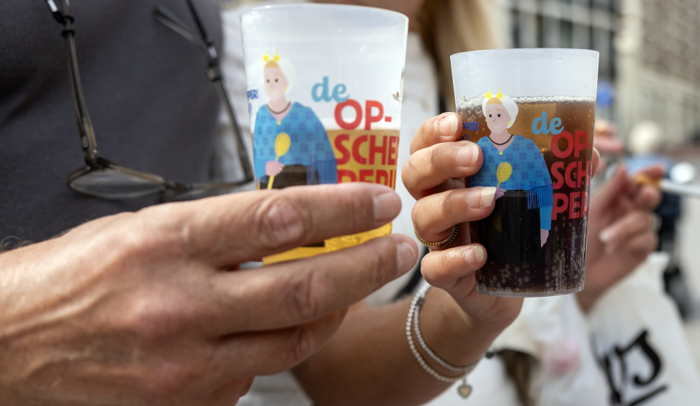 Twee glazen met kleurrijke illustraties in handen