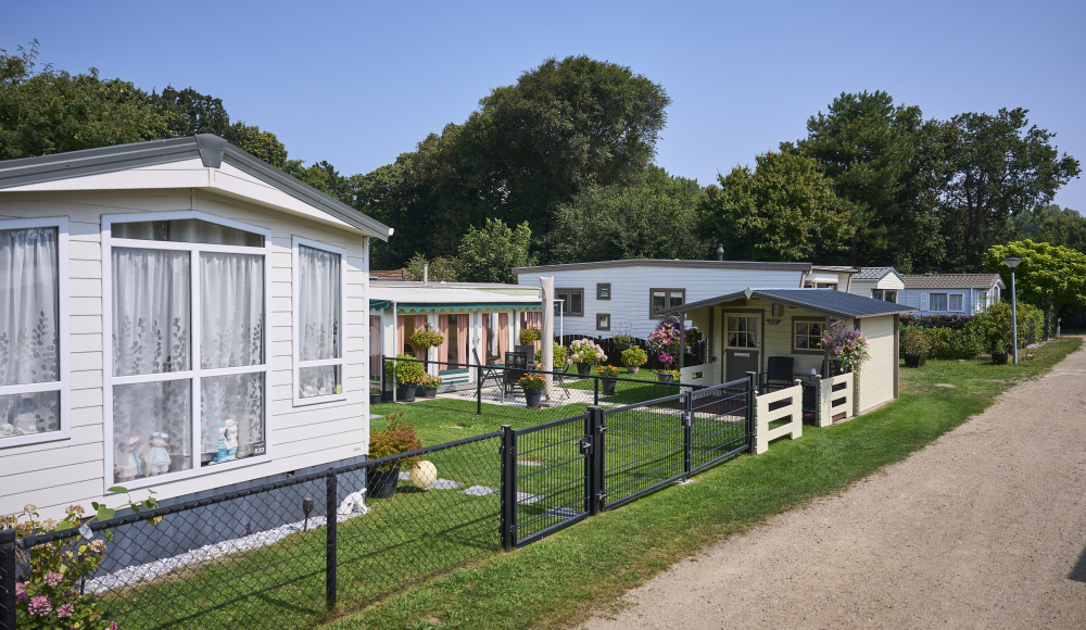 Eine Reihe von Ferienhäusern mit Blumen und Grün.