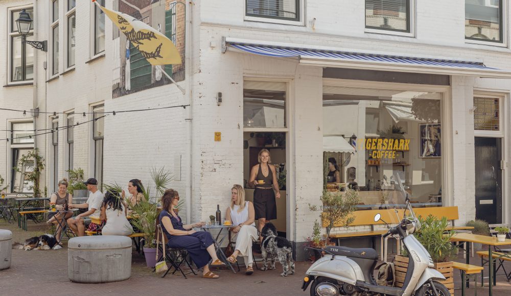 Mensen zitten op het terras van Gershark Coffee in Den Haag.