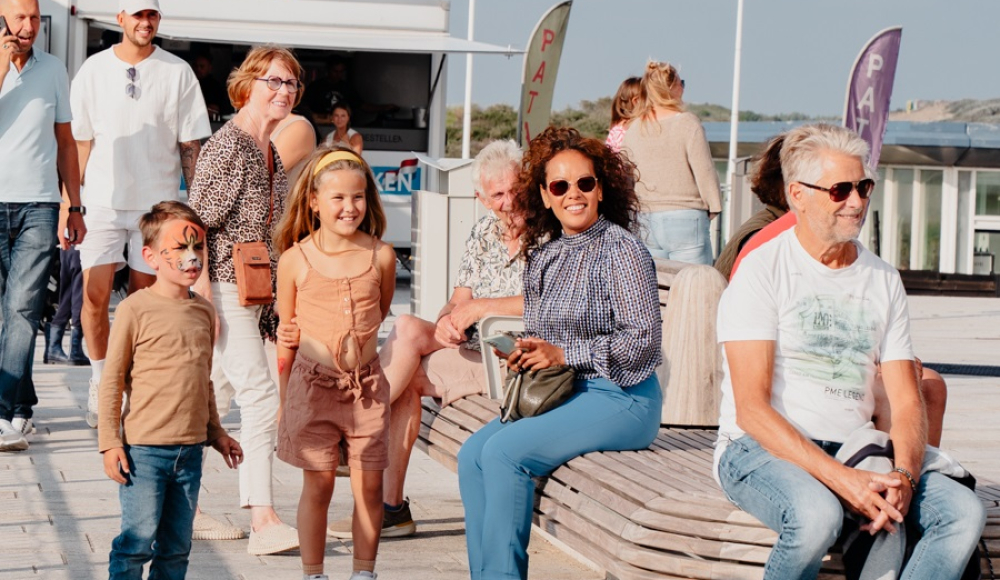 Groep mensen genietend op de pier, zonnige dag.