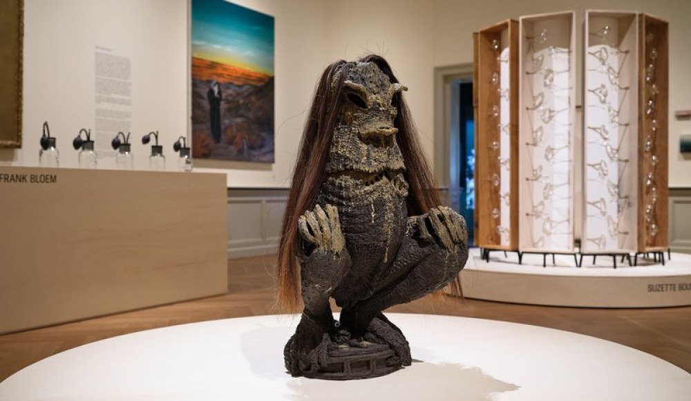 Een keramisch beeld van een creature met lange haren in een museum.