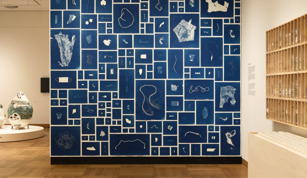 Een kunstwand met diverse witte afbeeldingen op een blauwe achtergrond.