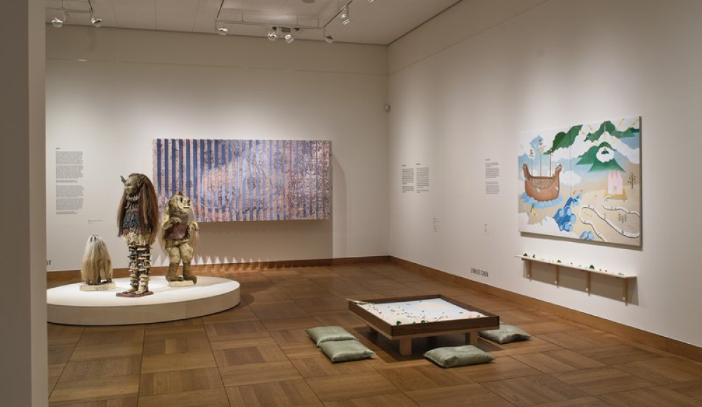 Een moderne kunsttentoonstelling met standbeelden en schilderijen.