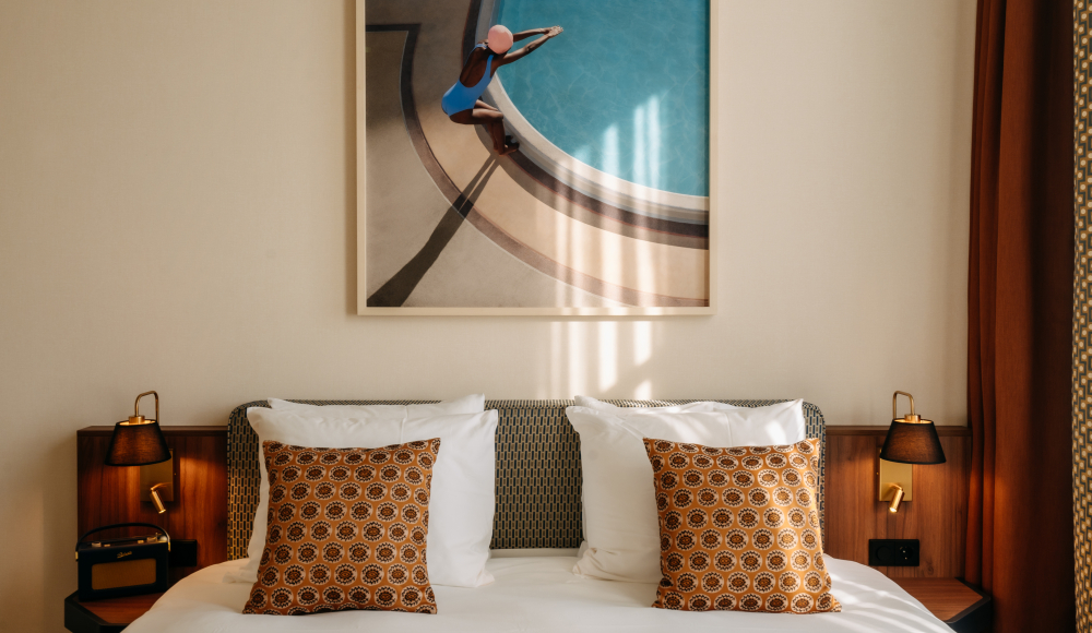 Deluxe Double Room met een bed met daarop kussens en warme houten accenten
