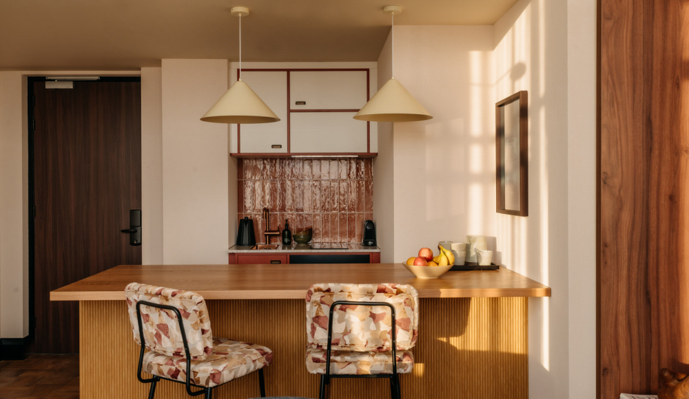Standard Suite Grand met een kitchenette met een houten bar en twee barkrukken 
