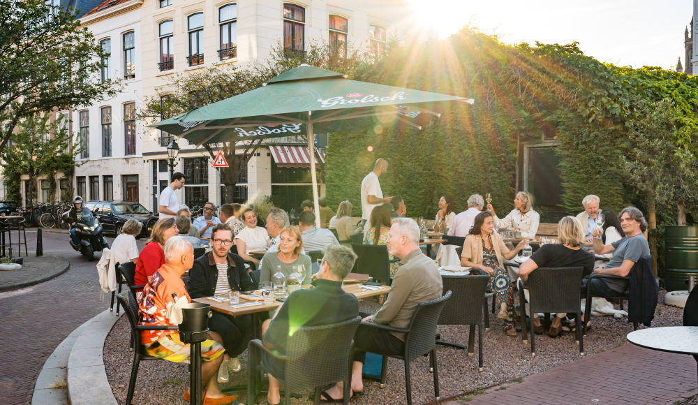 Mensen genieten op een terras in Den Haag.