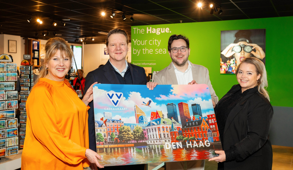 Vier mensen tonen een cadeaukaart van Den Haag.