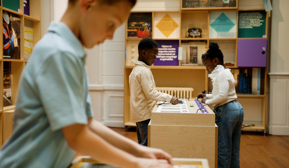 Three children exploring interactive displays in a museum.