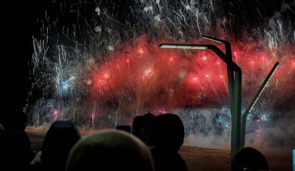 Vuurwerk in de lucht met kleurrijke explosiess, zichtbaar voor menigte.