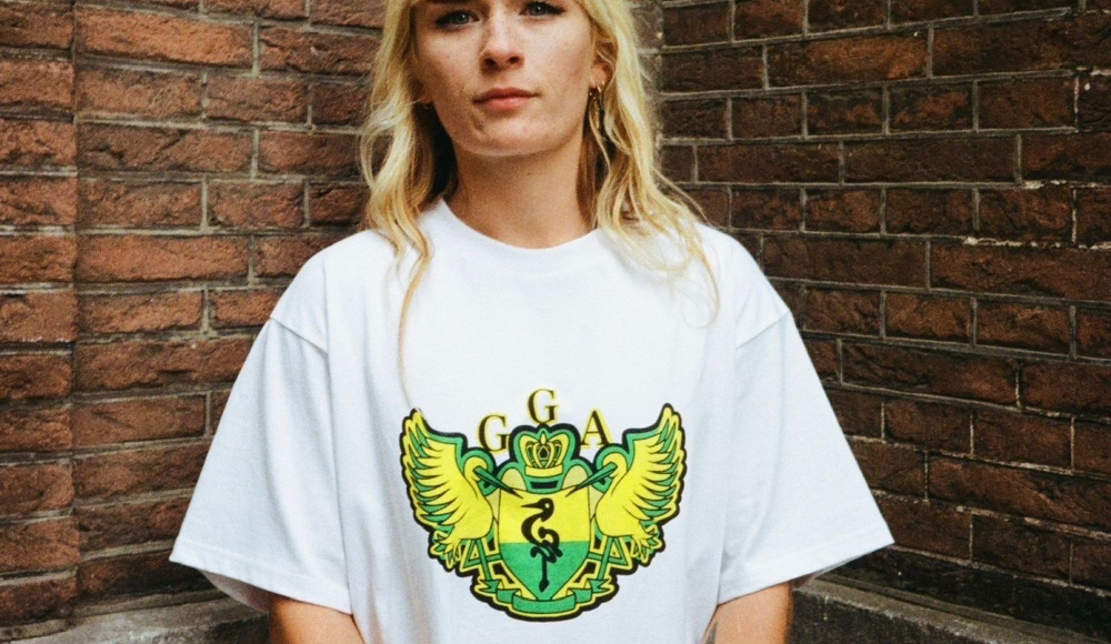 Vrouw met lang blond haar in een wit T-shirt met een kleurrijk logo. Vrouw met lang blond haar in een wit T-shirt met een kleurrijk logo.