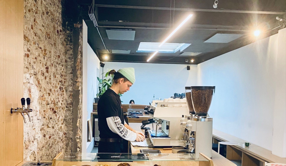 Barista achter de bar in een hippe koffiezaak. 