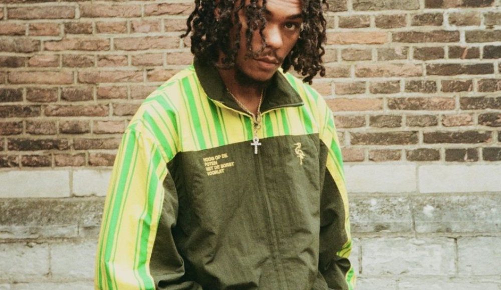 Man met krullend haar in een groen-gele outfit van Groen Gele Aderen. Man met krullend haar in een groen-gele outfit van Groen Gele Aderen.