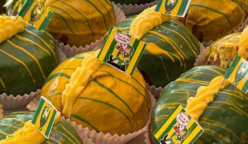 Groene en gele oliebol met een crème topping en vlaggetjes.