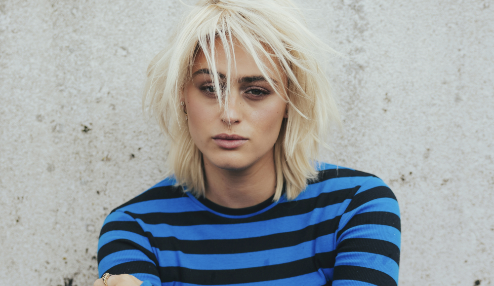 Porträt einer jungen Person mit blonden Haaren und gestreiftem Shirt