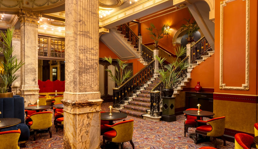 Stijlvol restaurantinterieur met marmeren pilaren en een trap.