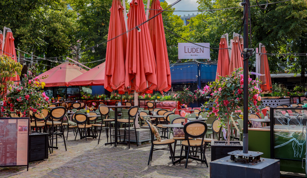 Terras buiten op het Plein van Restaurant Luden met rode parasols