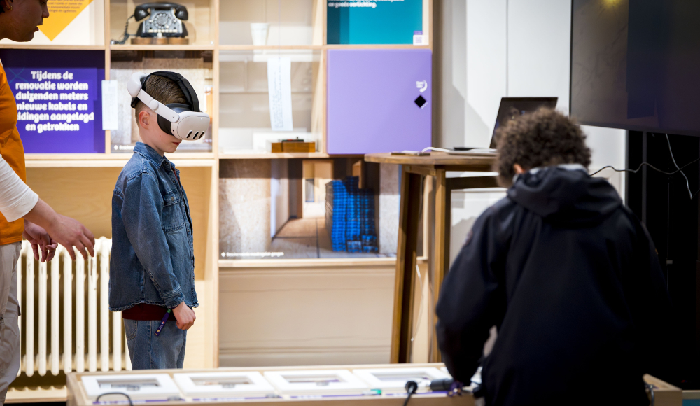 Een jongen met een VR-bril en een volwassene in een museum.