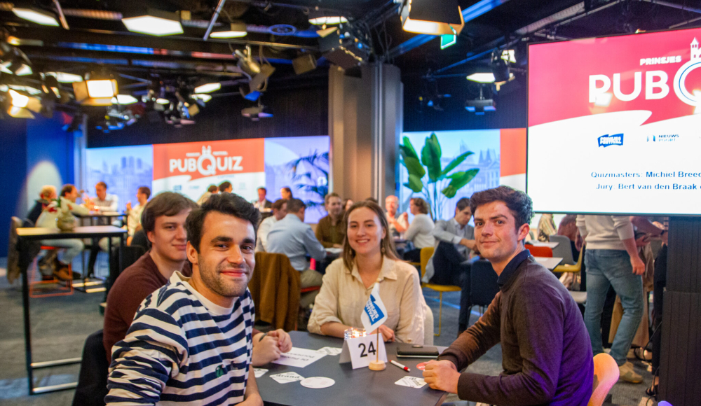 Groep vrienden aan tafel tijdens pubquiz event (c) Michon Leenders