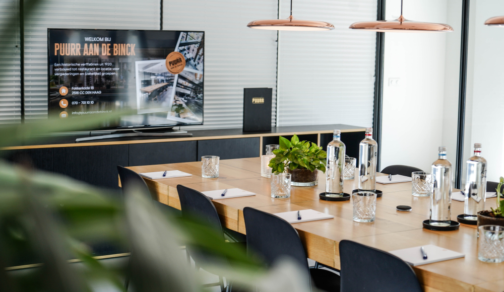 Salle de réunion moderne avec des plantes et une télévision.