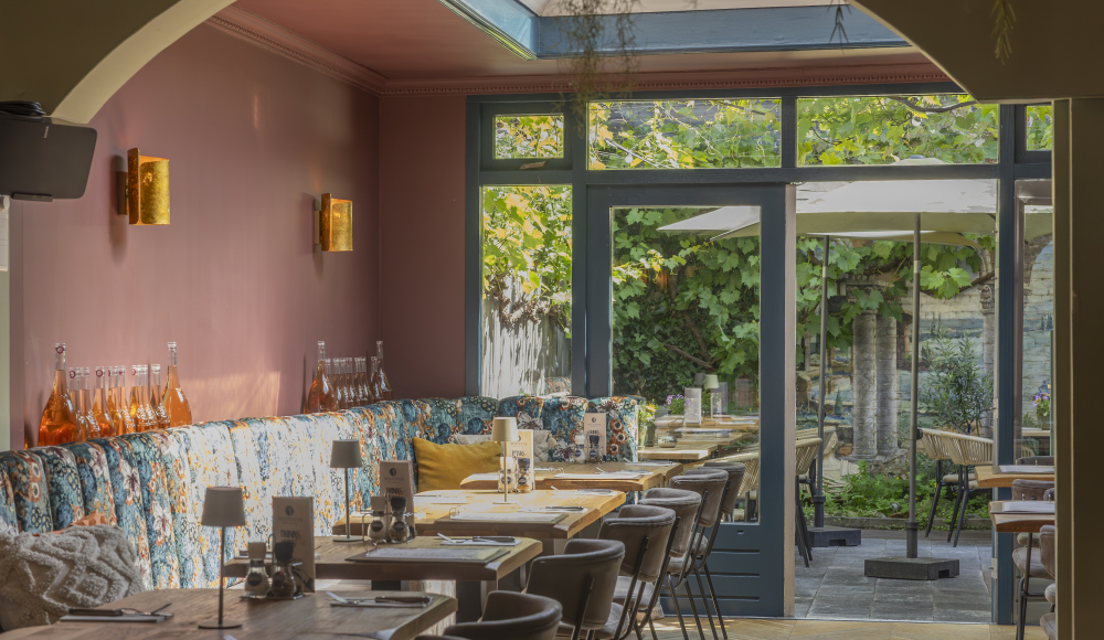 Een ingericht restaurant met een groene tuin.