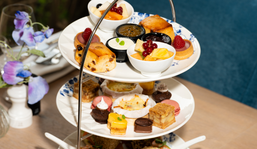 Drie lagen met scones, gebakjes en fruit op een etagère