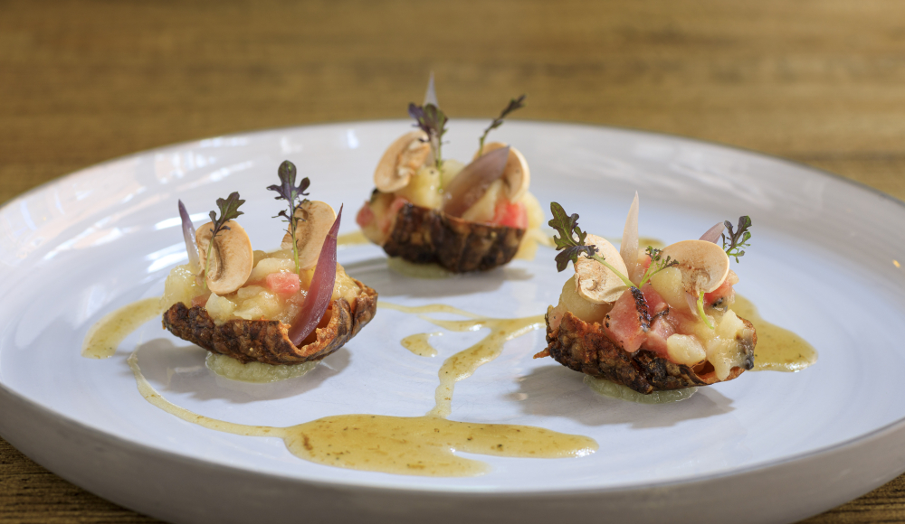 Trois petits apéritifs avec garniture sur une assiette blanche.