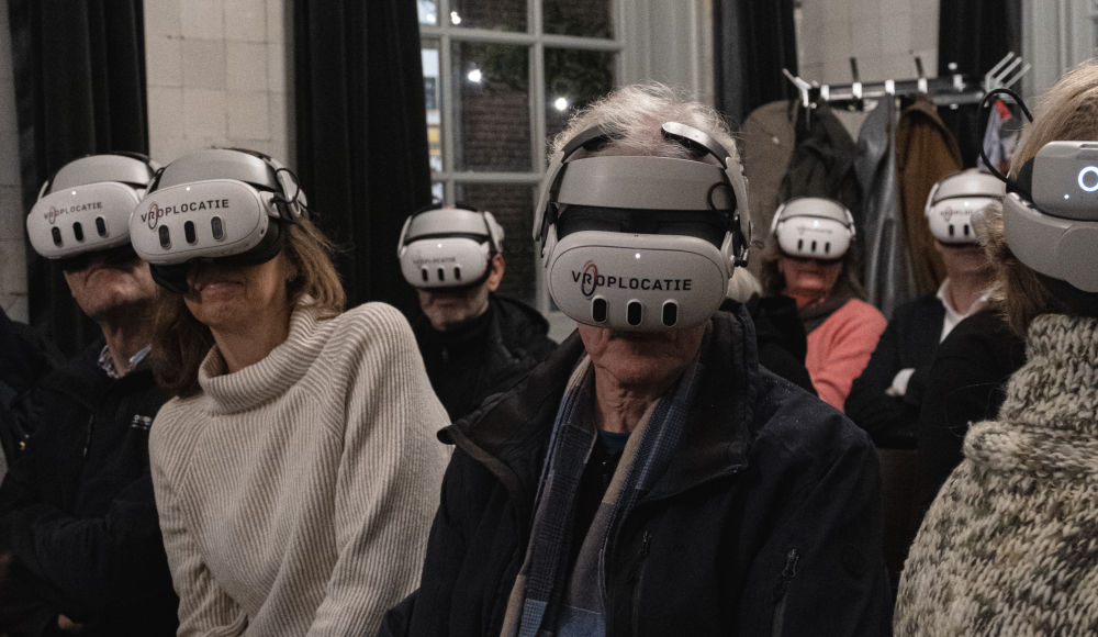 Mensen met VR-brillen zitten in een zaal.