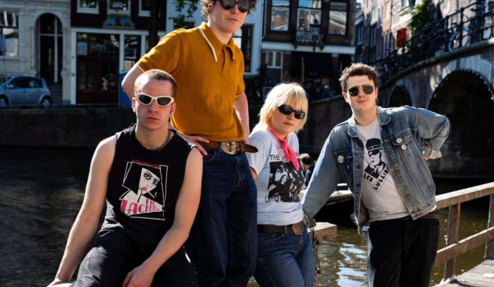 Vier jongeren poseren met een gracht op de achtergrond