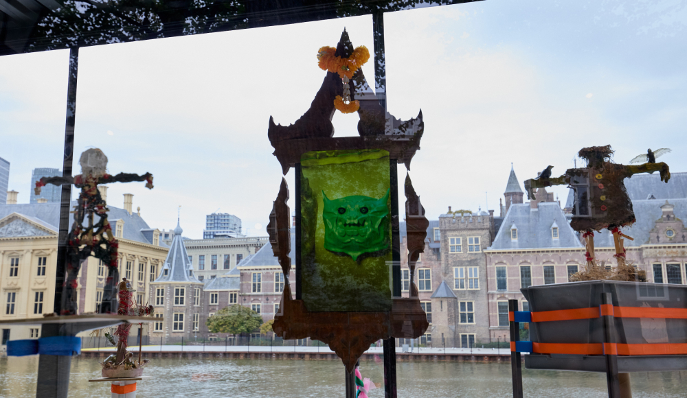 Twee kleurrijke kunstwerken voor het Binnenhof, weerspiegeld in het water.