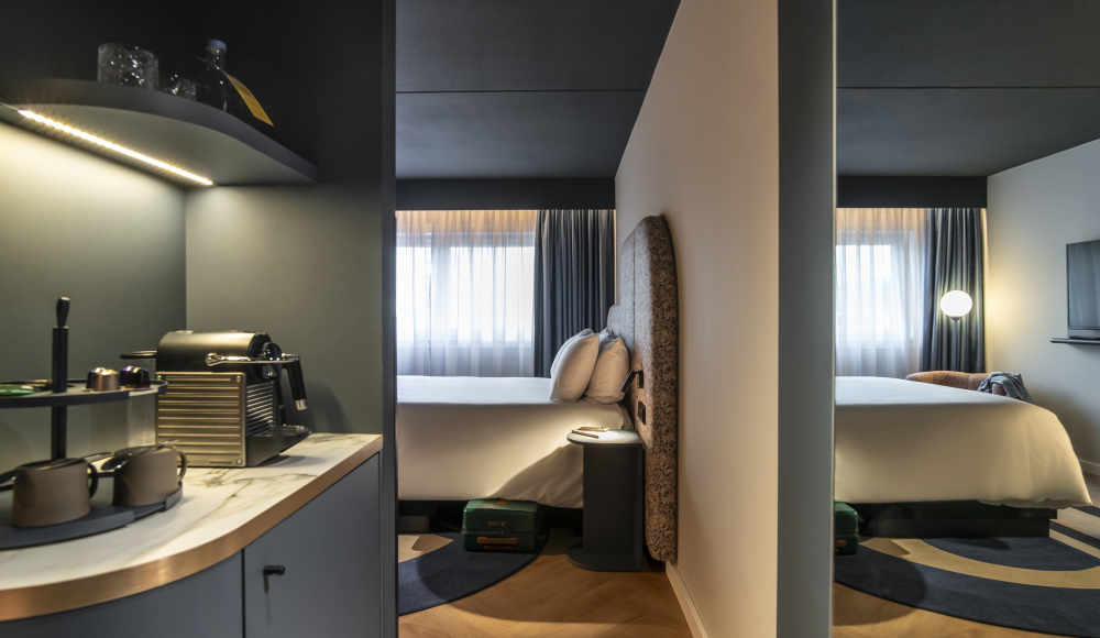 Twee hotelbedden met minimalistisch ontwerp en koffievoorzieningen.