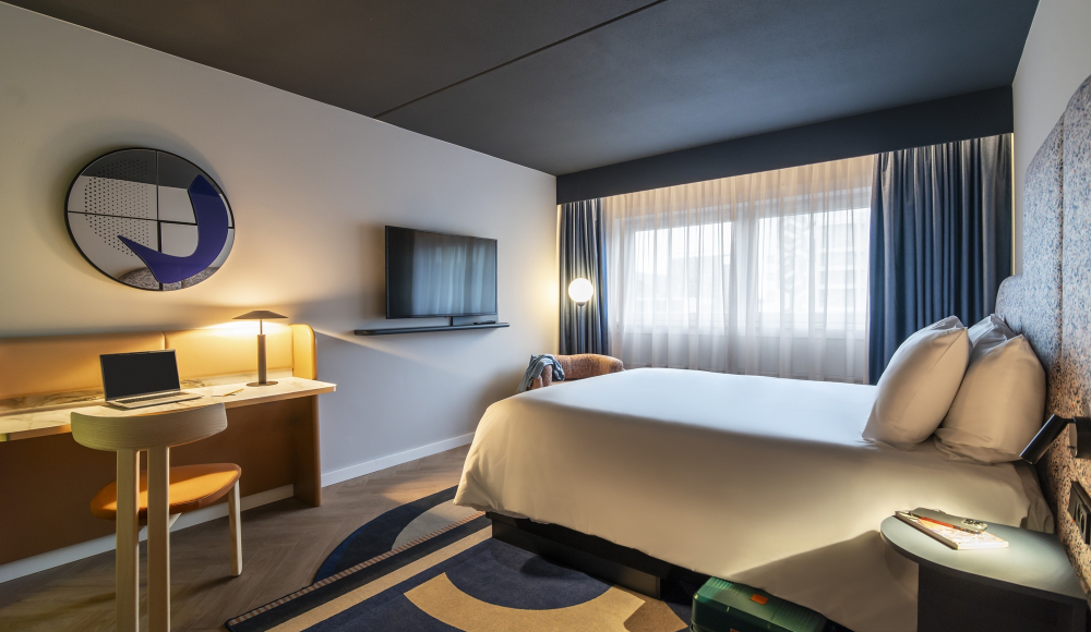 Stijlvolle hotelkamer met bed, bureau en tv