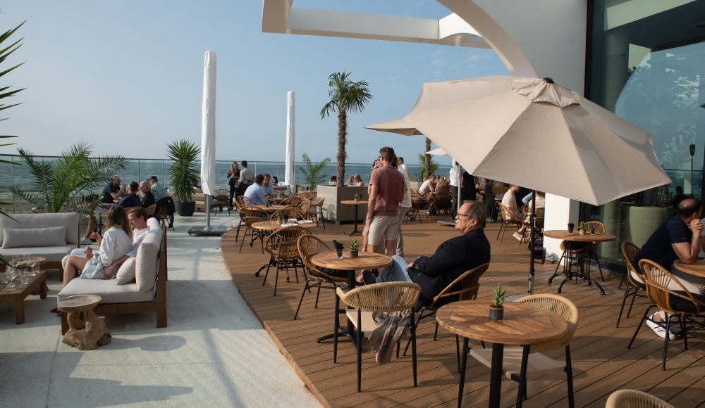 Zonnig terras van REBORN Whitehouse met uitzicht op zee
