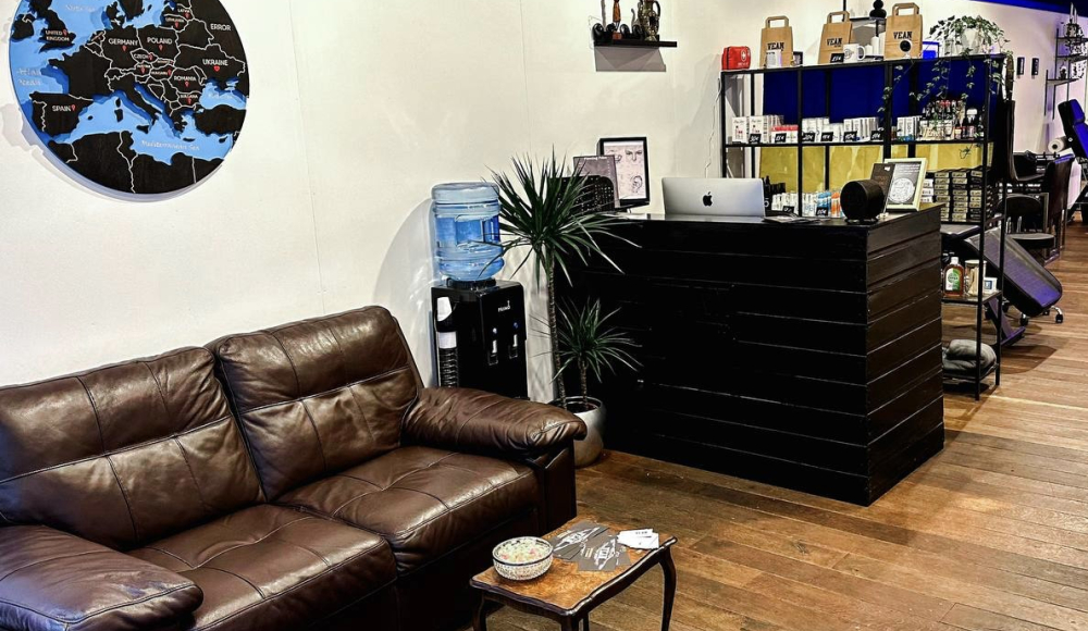 A brown sofa, a water dispenser, and a black desk