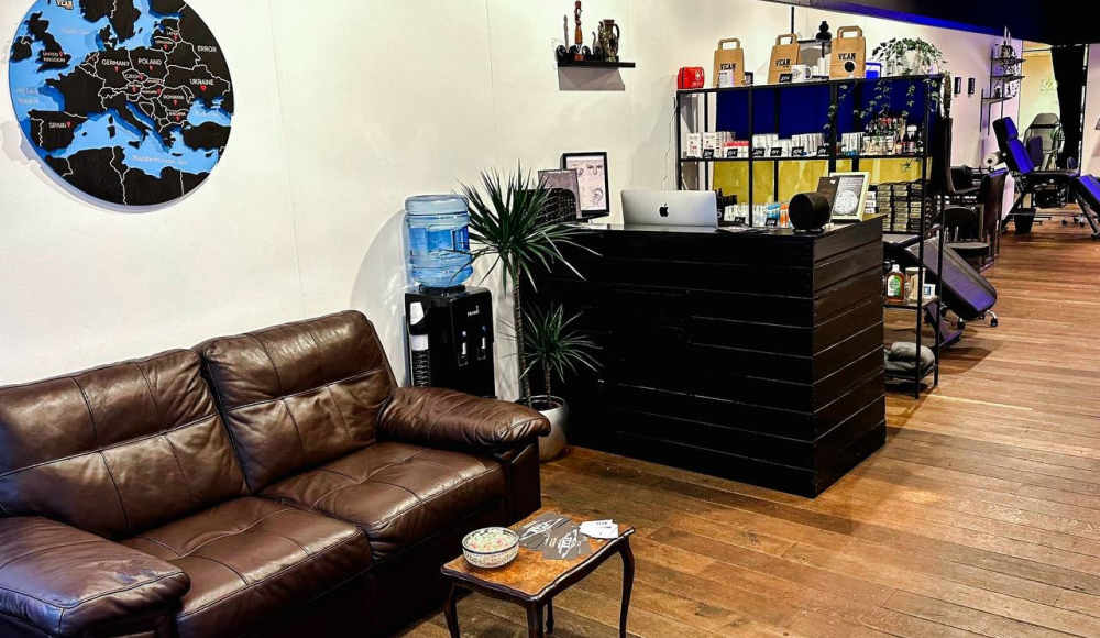 A leather couch, a counter with products, and a world map on the wall.