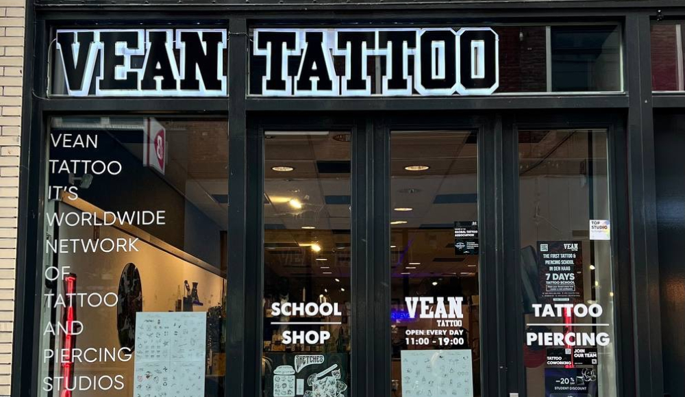 The entrance of Vean Tattoo showing opening hours and studio details.