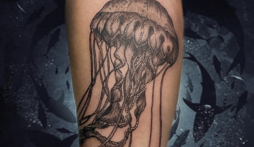 A tattoo of a jellyfish on an arm.